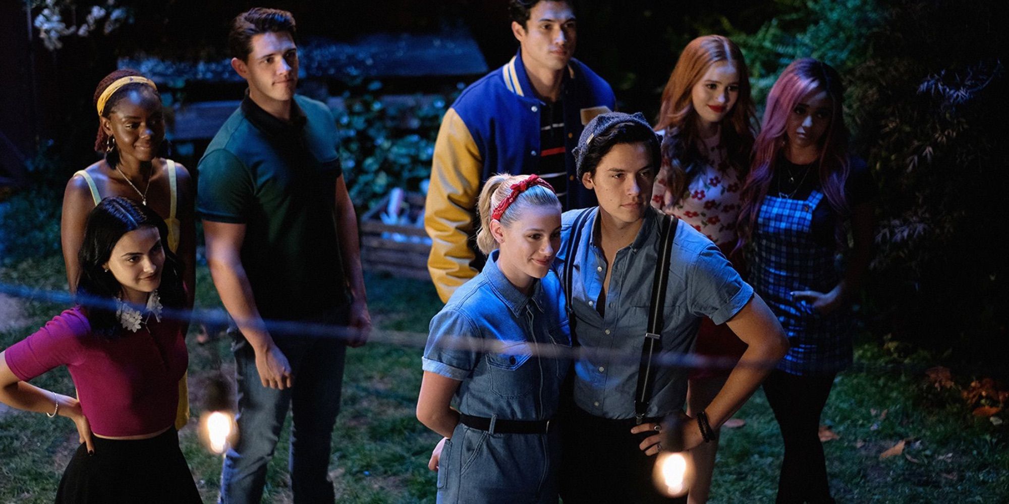 The cast of Riverdale standing in a field at night