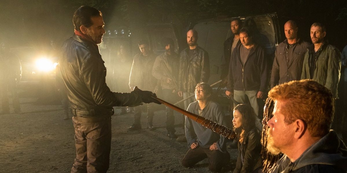 Negan intimidates Rick and his allies with his barbed-wire baseball bat as his follows surround them.