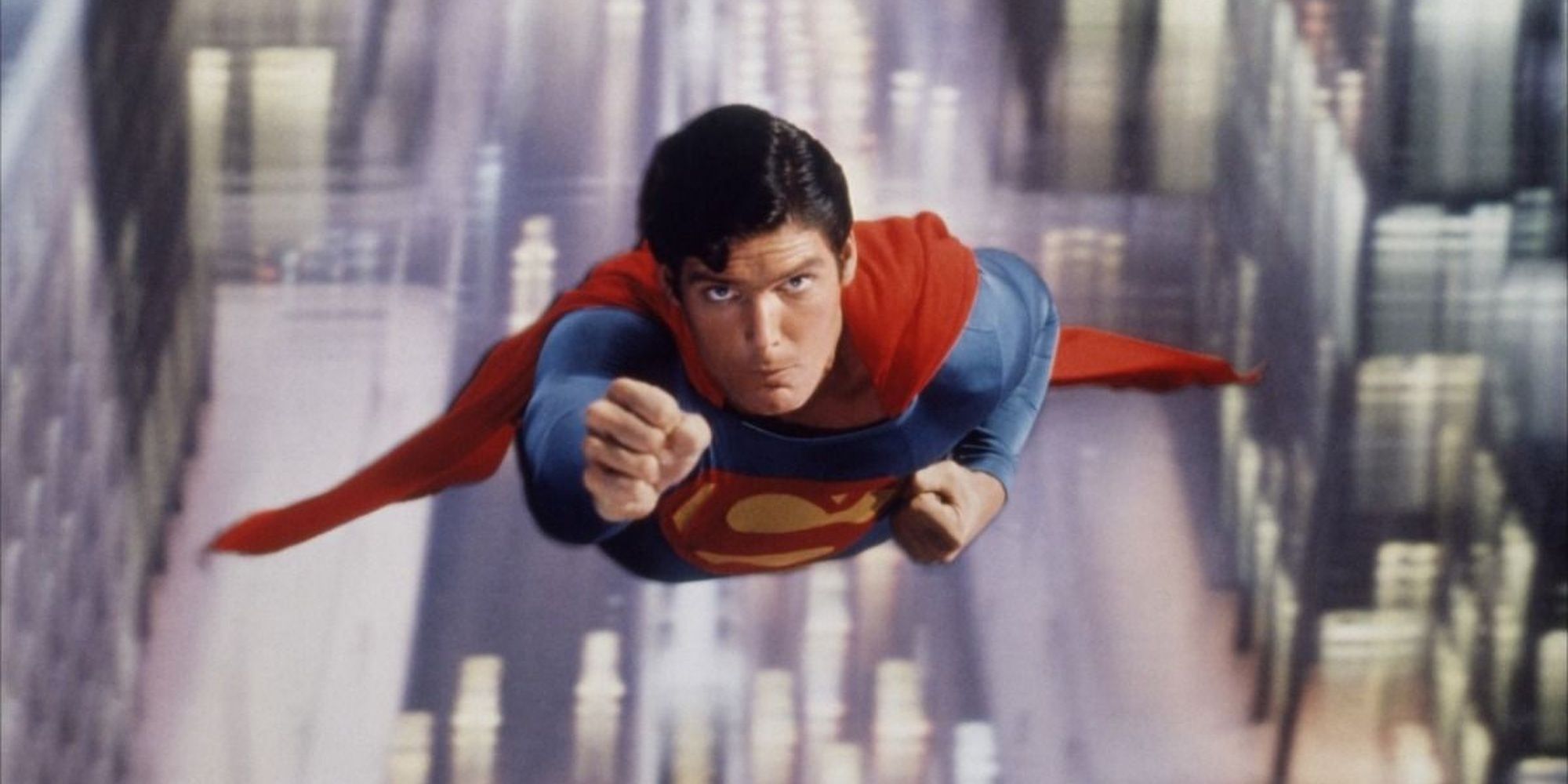 Christopher Reeve soaring through a city in Superman