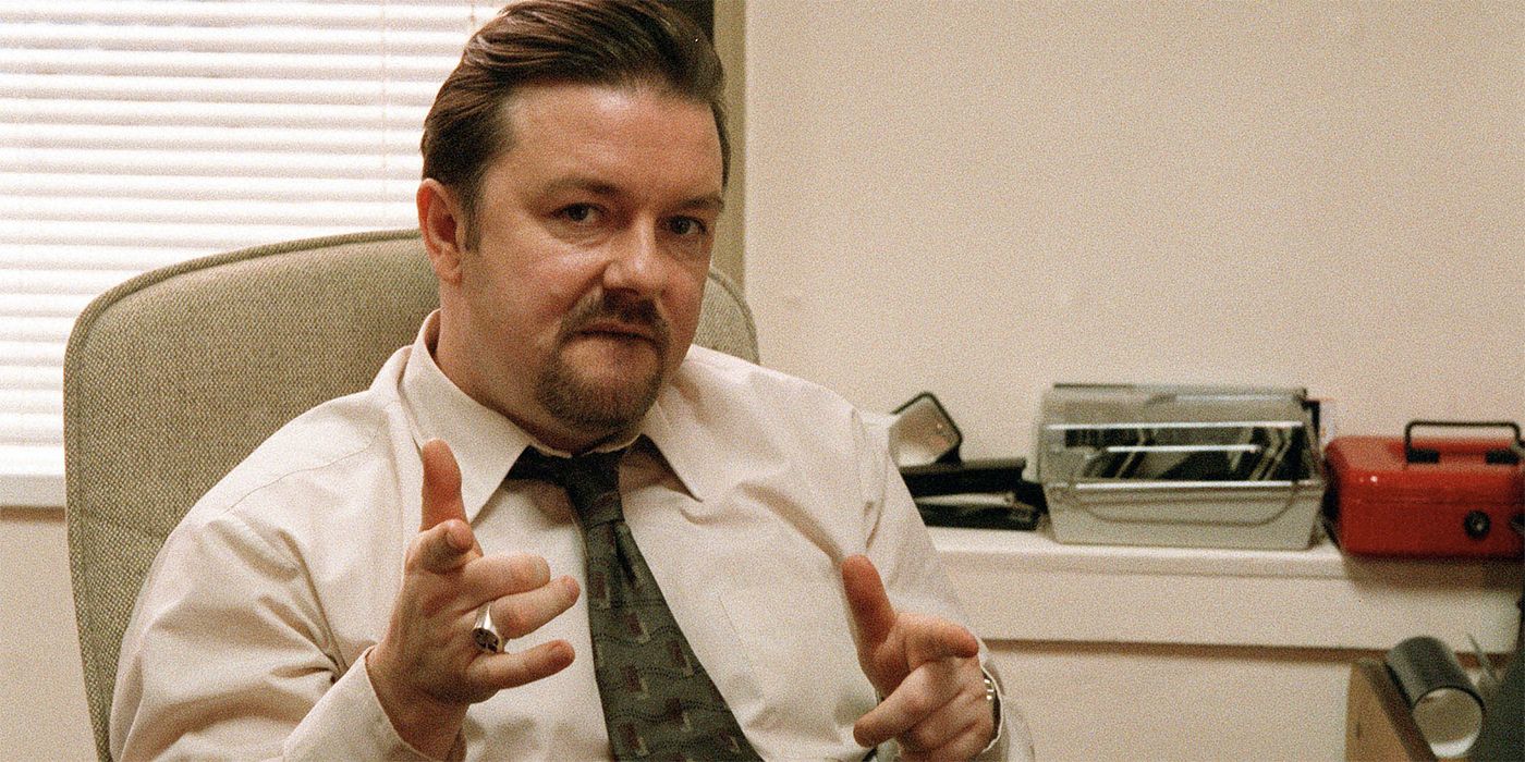 Ricky Gervais as David Brent in a button down shirt and tie with a ring on his right hand in The Office