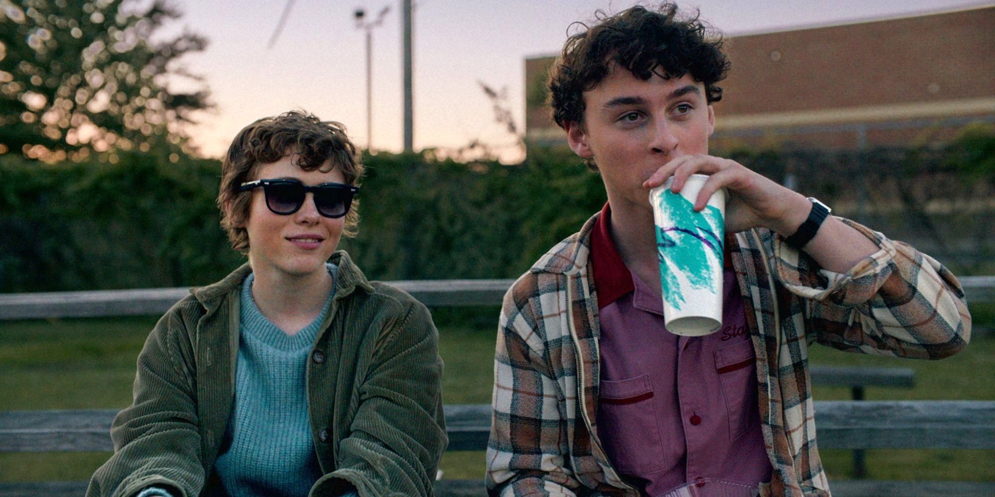 Sophia Lillis and Wyatt Oleff sitting at a park bench and looking in the same direction in I Am Not Okay With This.