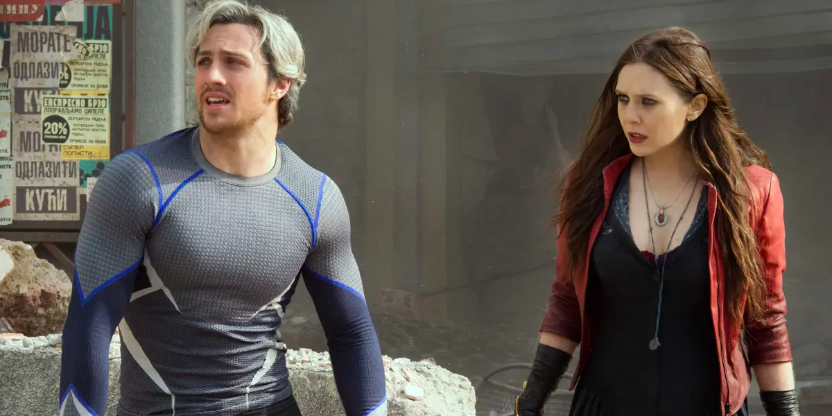 Aaron Taylor Johnson as Pietro and Elizabeth Olsen as Wanda stand in rubble in Avengers Age of Ultron.