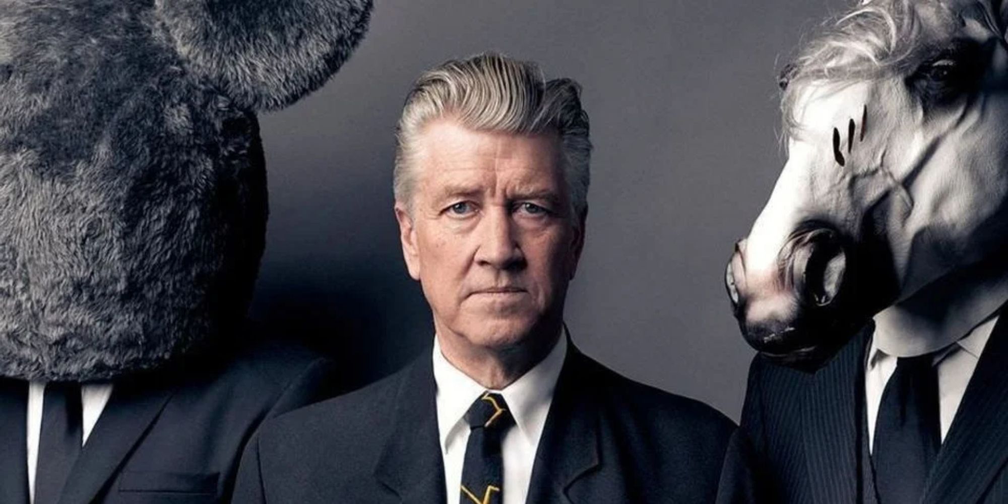 David Lynch, a man with a horse head, a man with a furry mascot head, both in suits.