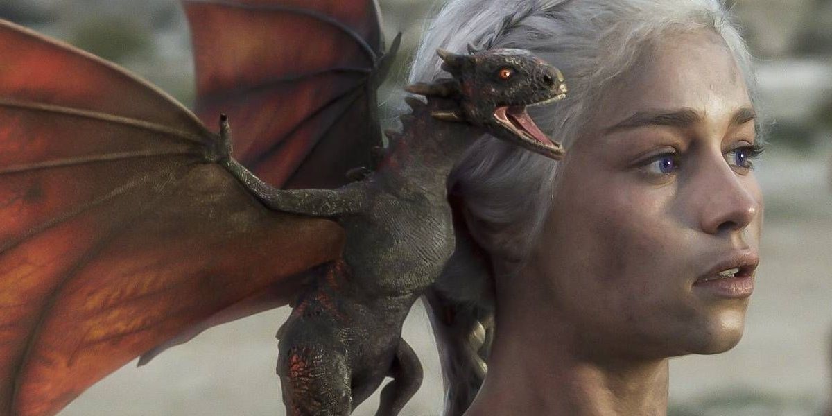 Emilia Clarke as Daenerys Targaryen emerges from the ashes, unscathed, with a baby dragon on her shoulder.