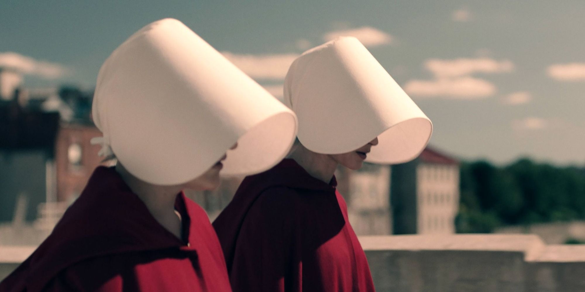 Handmaids walking with their heads down