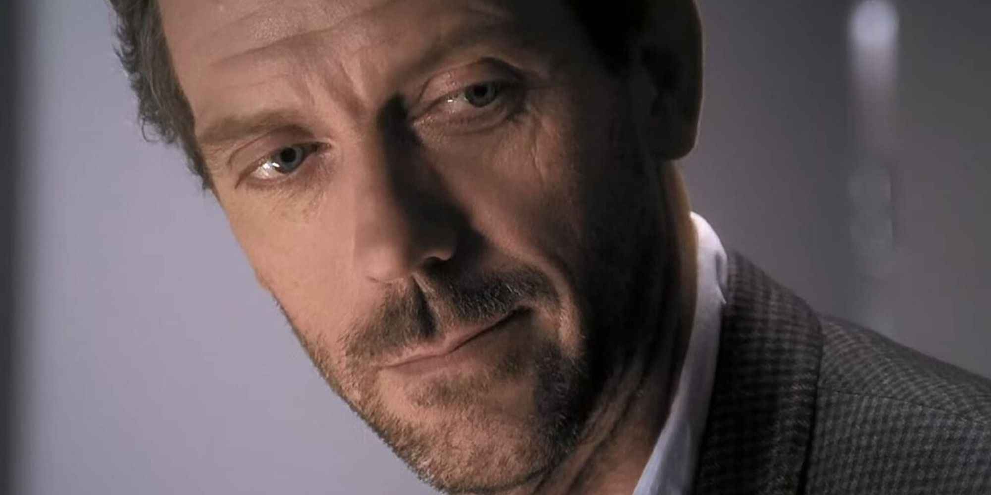 Gregory House looking down smiling