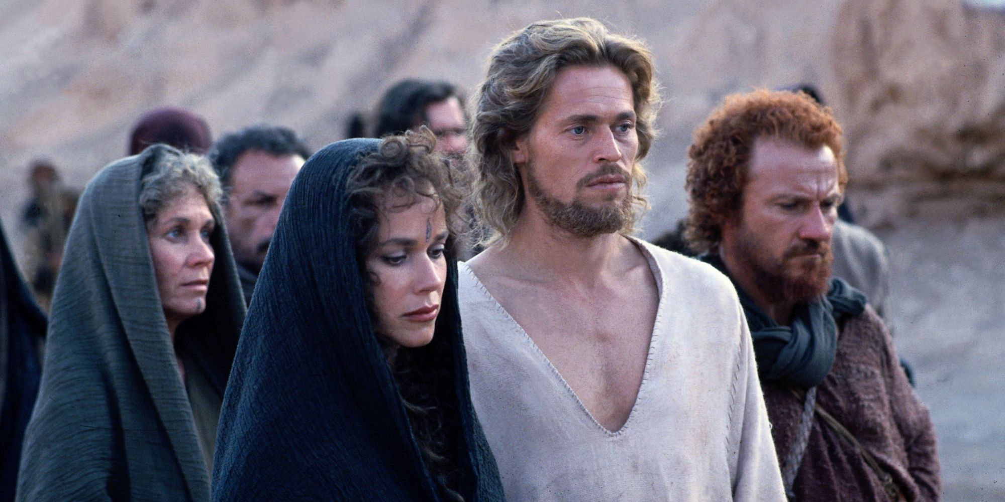Barbara Hershey, Willem Dafoe, and Harvey Keitel as Mary Magdalene, Jesus Christ, and Judas Iscariot among a group of pilgrims in The Last Temptation of Christ