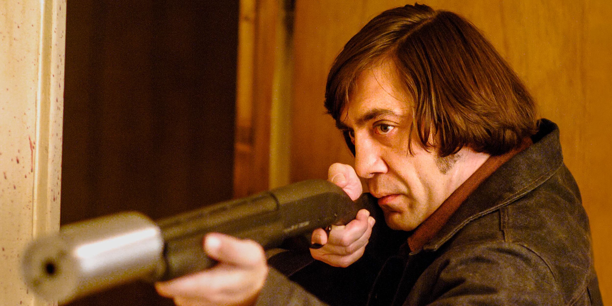 Javier Bardem as Anton Chigurh holding a shotgun in No Country For Old Men