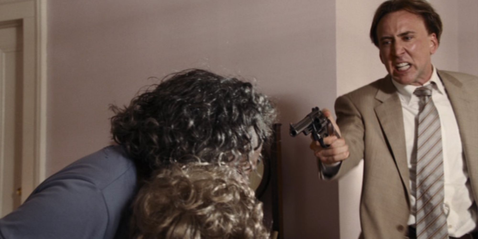 Nicolas Cage in Bad Lieutenant points gun angrily at two old ladies