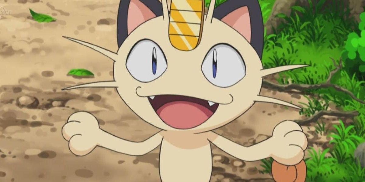 With a wide open smile, Team Rocket's Meowth stands on a road.