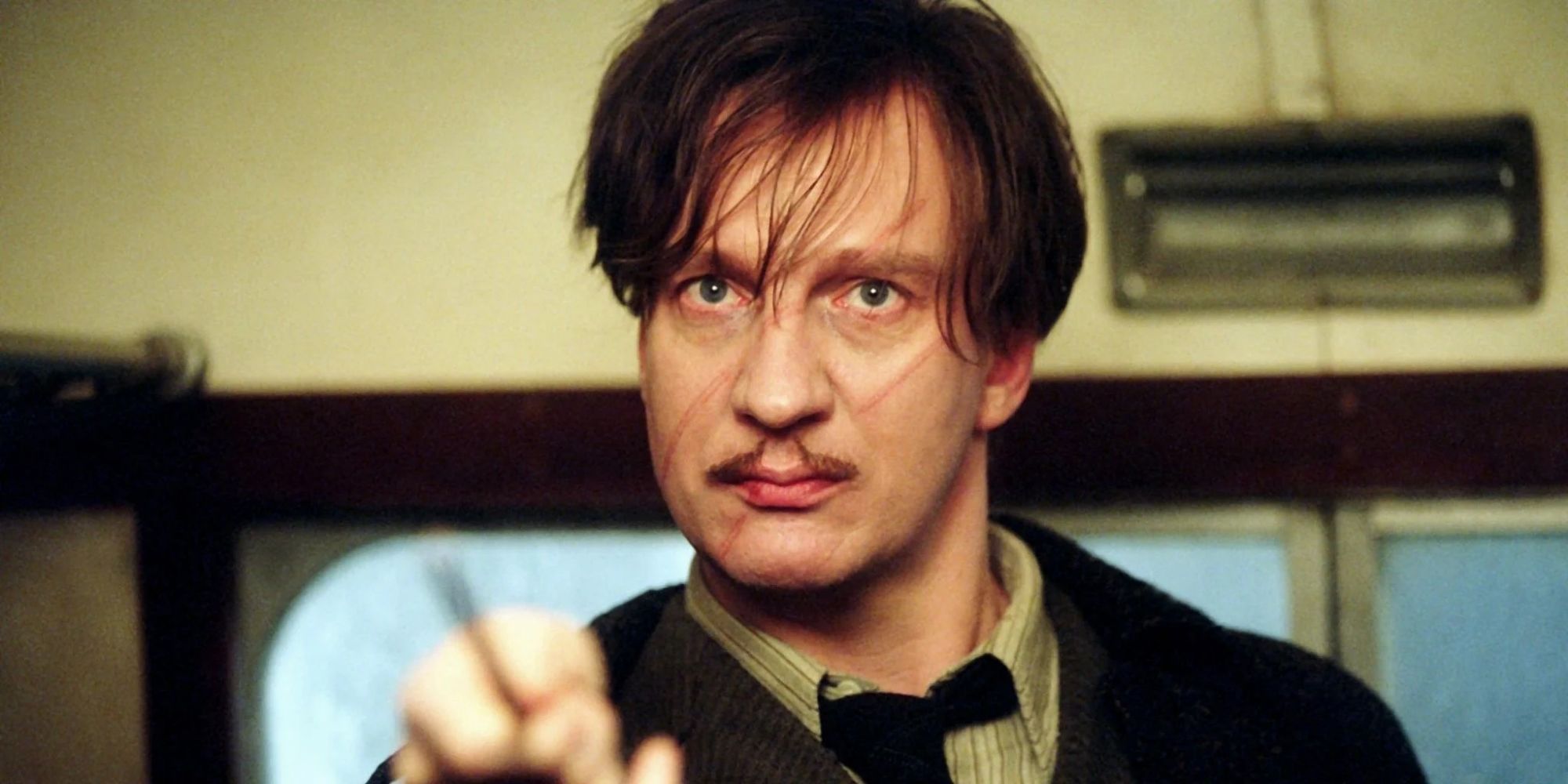 Remus Lupin pointe sa baguette vers quelque chose hors champ dans Harry Potter et le Prisonnier d'Azkaban.