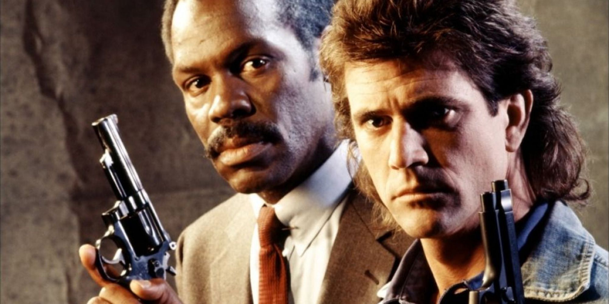 Mel Gibson como Riggs e Danny Glover como Murtaugh de Máquina Mortífera, carregando armas