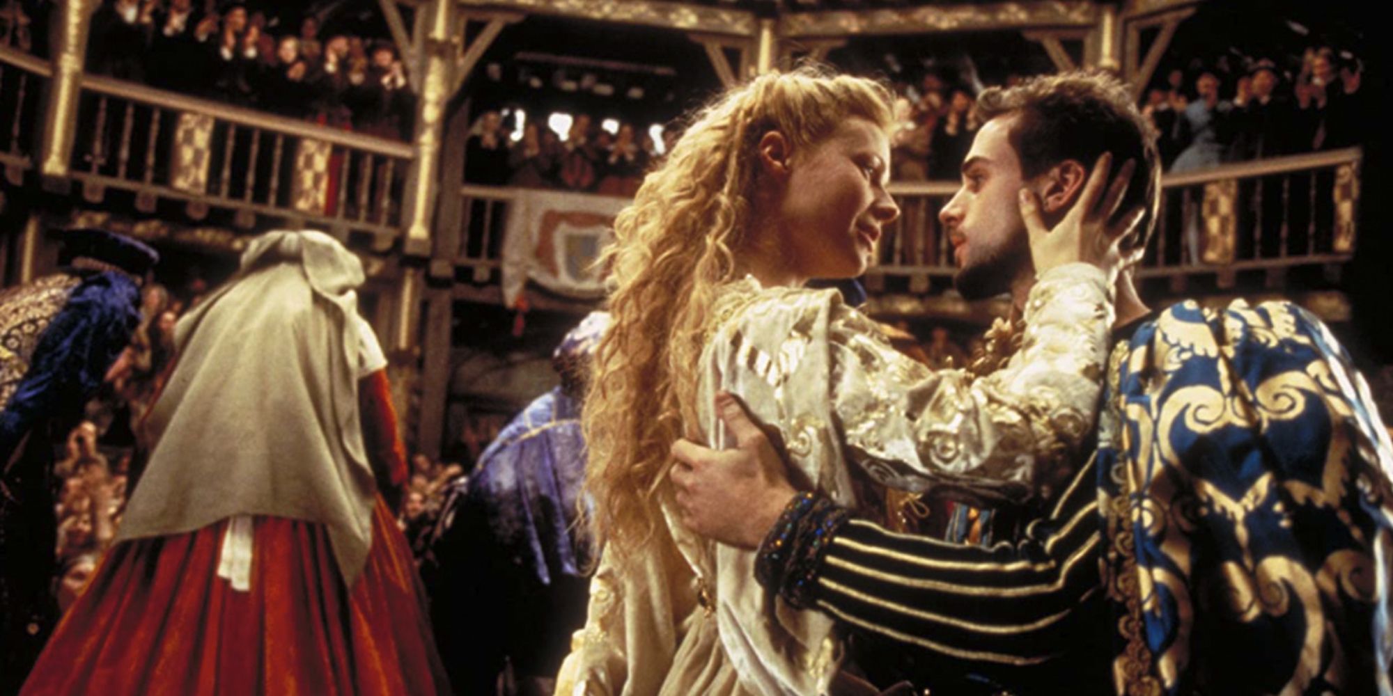 Viola and Will embracing on stage while a crowd cheers in Shakespeare In Love