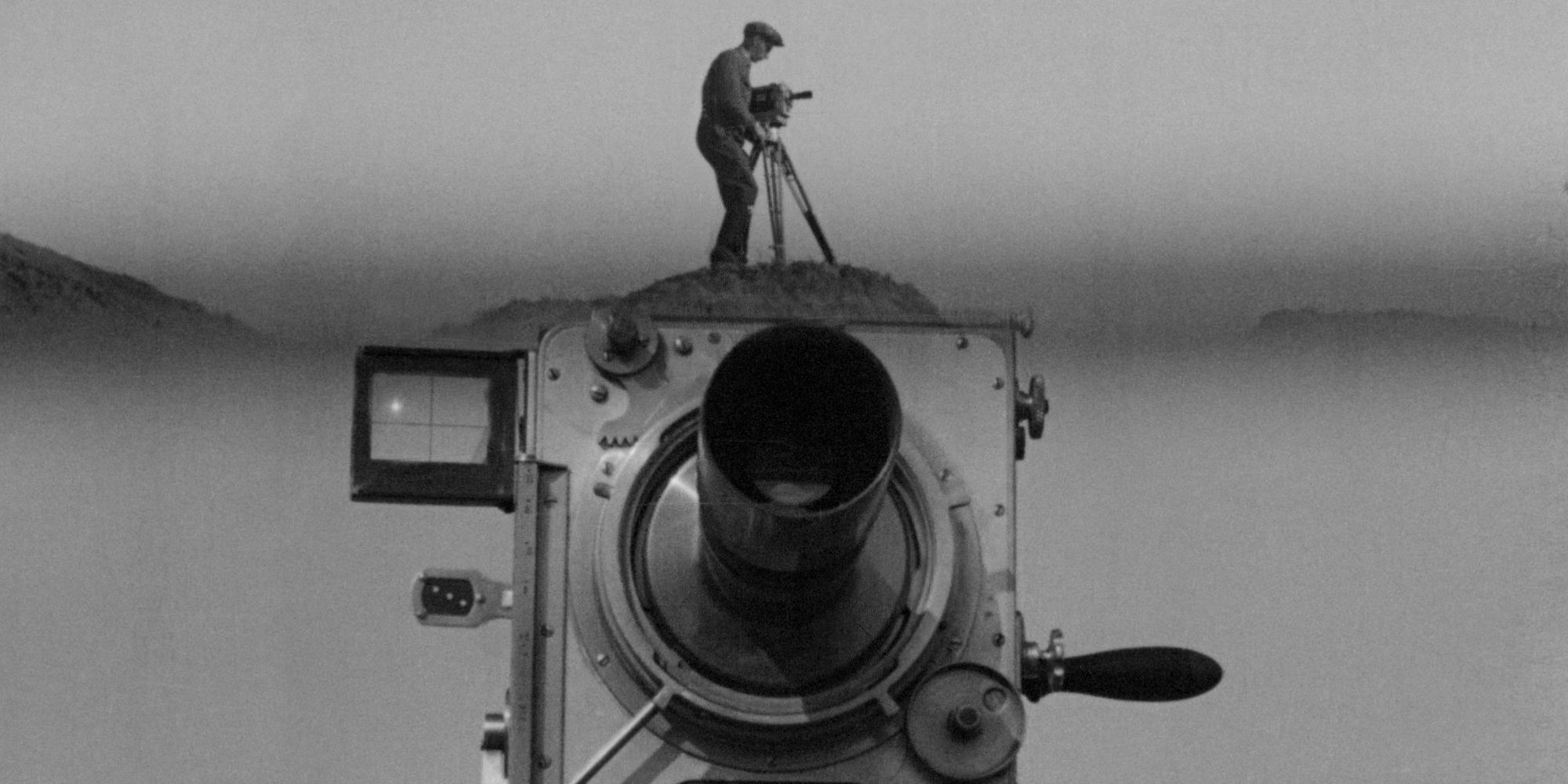 A man standing atop a giant movie camera in Man With a Movie Camera