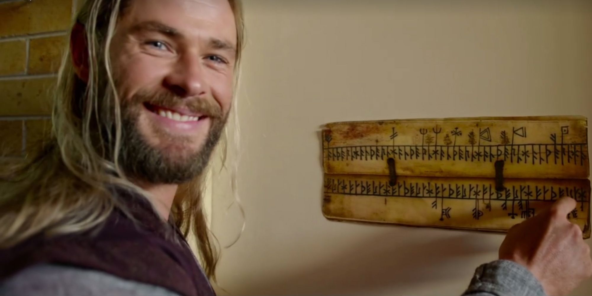 Thor pointing at a sign with Asgardian runes