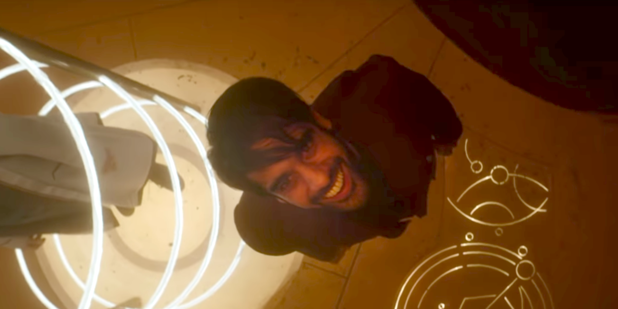 The Master cackles at the ceiling while the Doctor is trapped in a laser prison