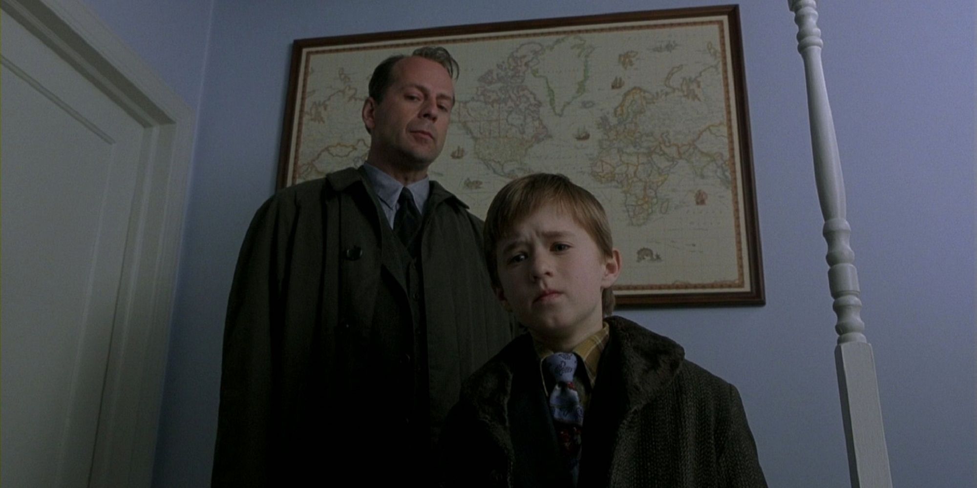 A child psychiatrist stands with a young boy looking down at something which scares the child. 