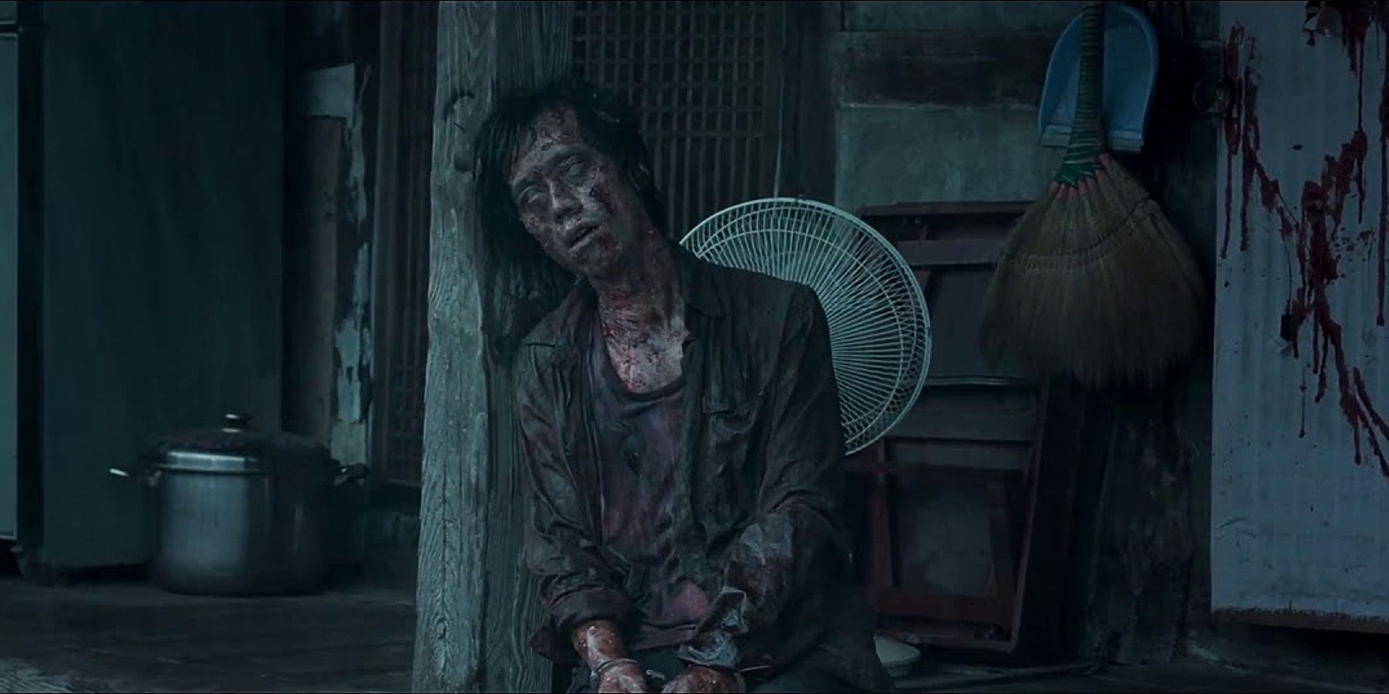 A dirty, blood-covered demon sitting in 2016's The Wailing
