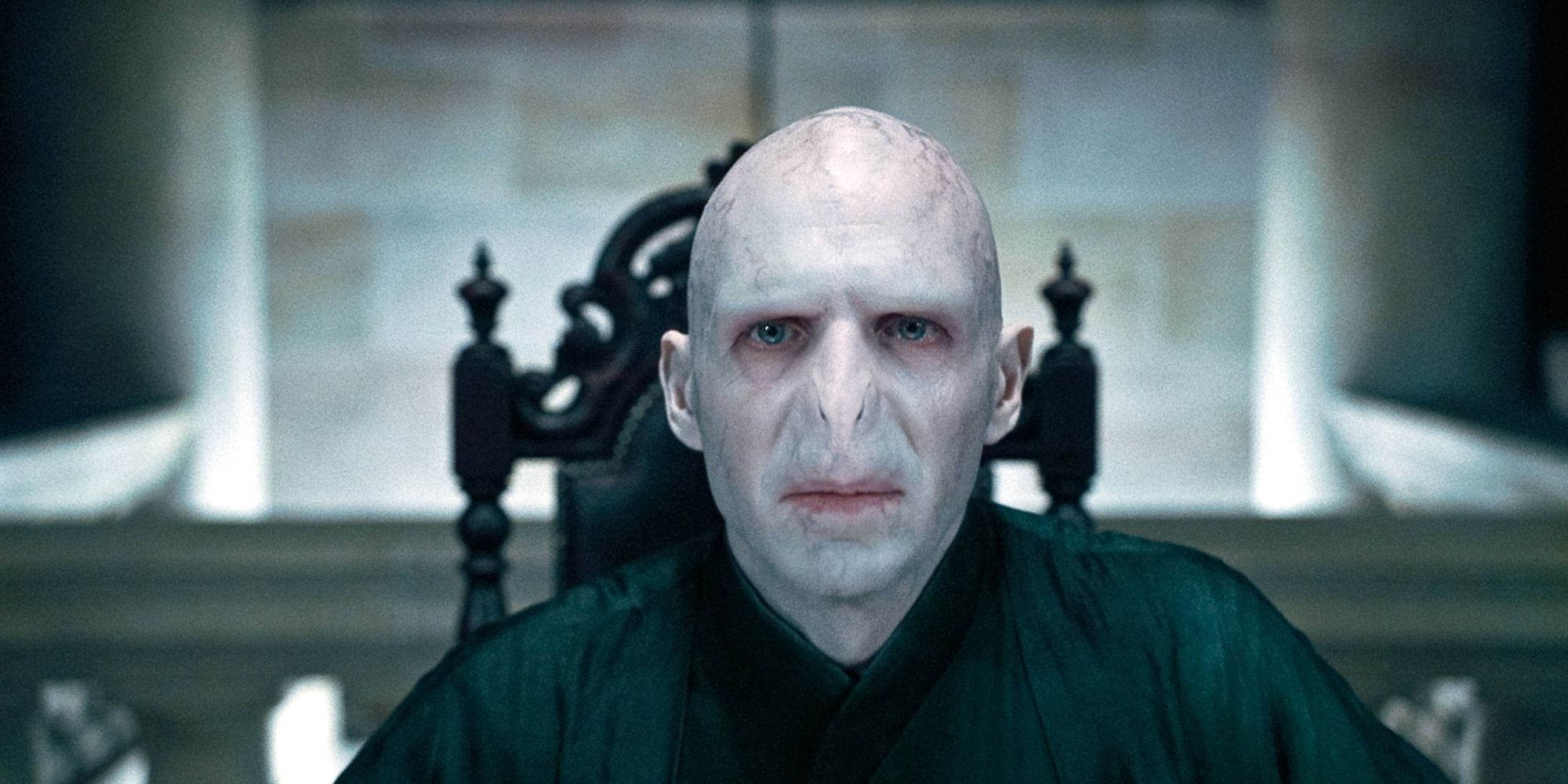 Lord Voldemort assis au bout d'une table dans Harry Potter et les reliques de la mort, partie 1.