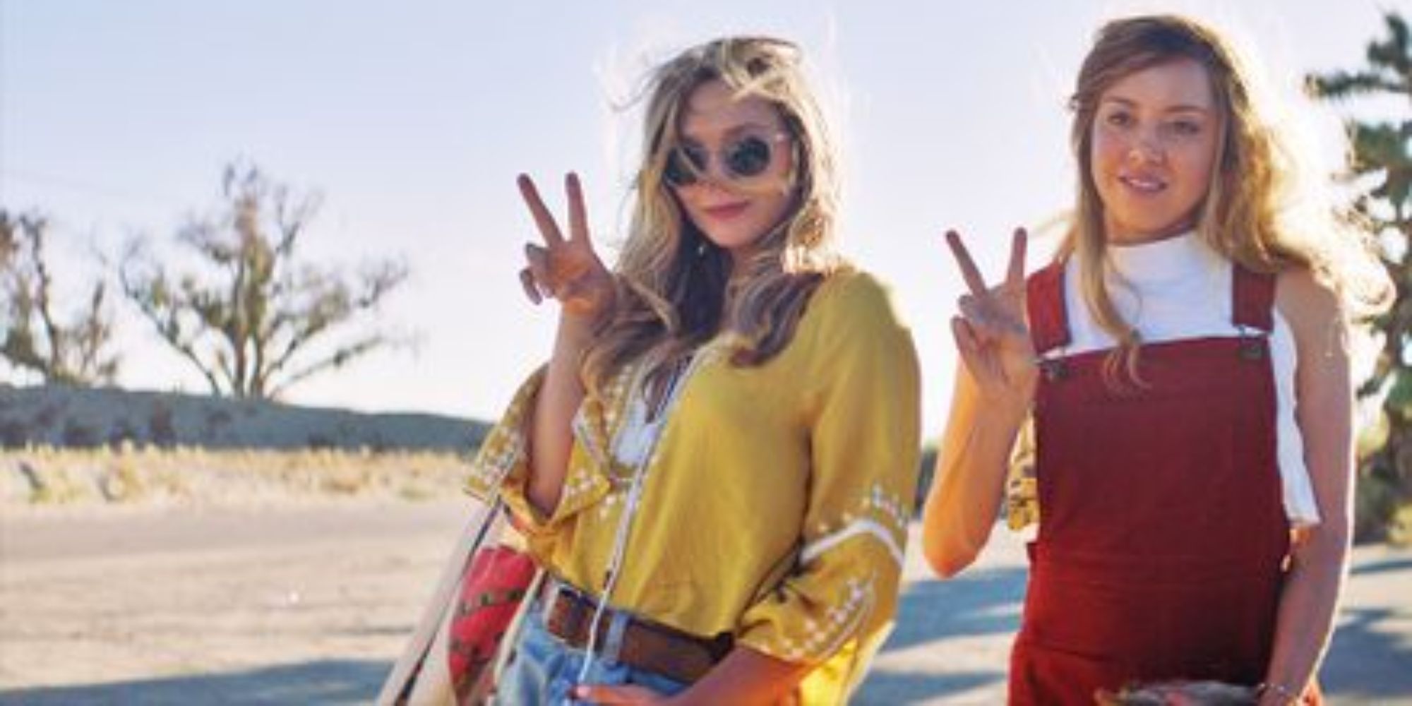 Ingrid and Taylor at the desert posing for a photo while doing the peace sign in Ingrid Goes West.