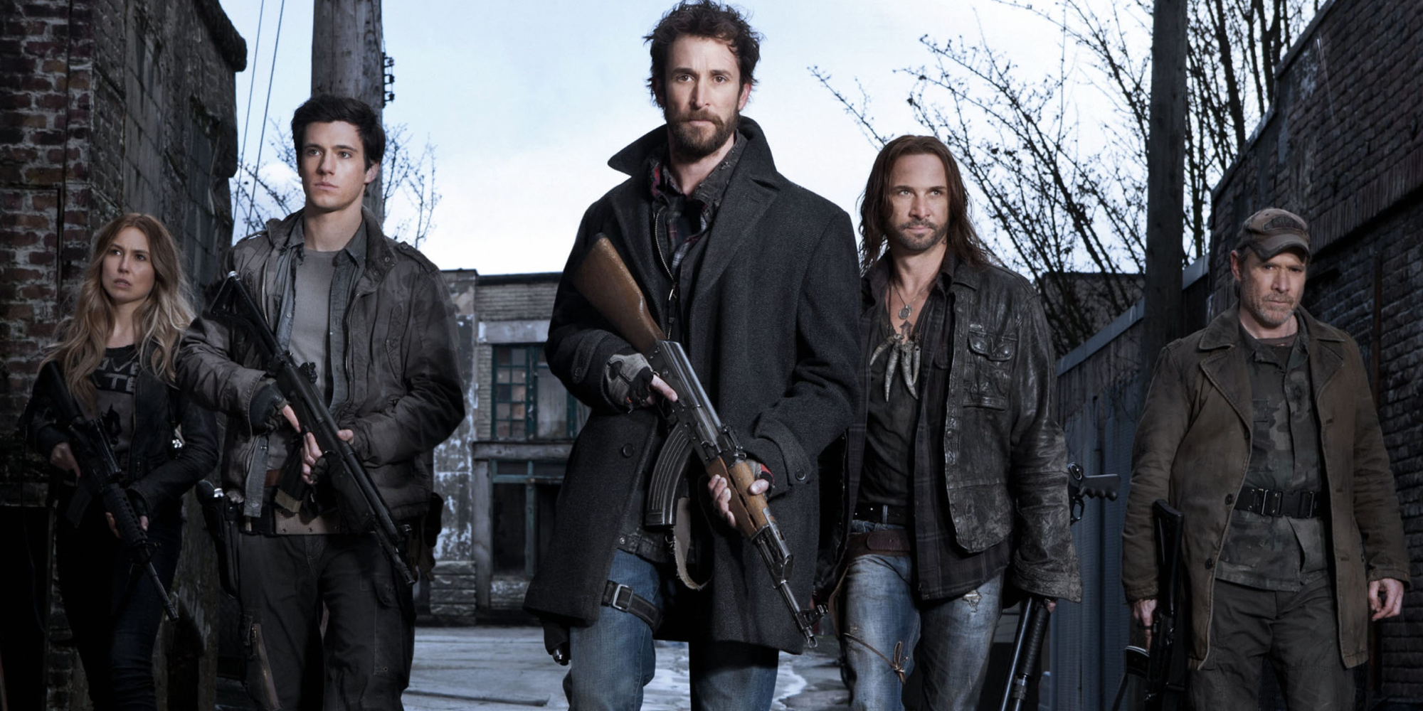 falling-skies main cast walk down an alleyway with weapons