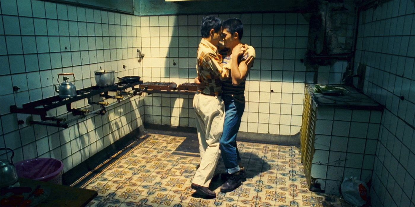 Leslie Cheung and Tony Leung slowing dancing in a kitchen together in Happy Together