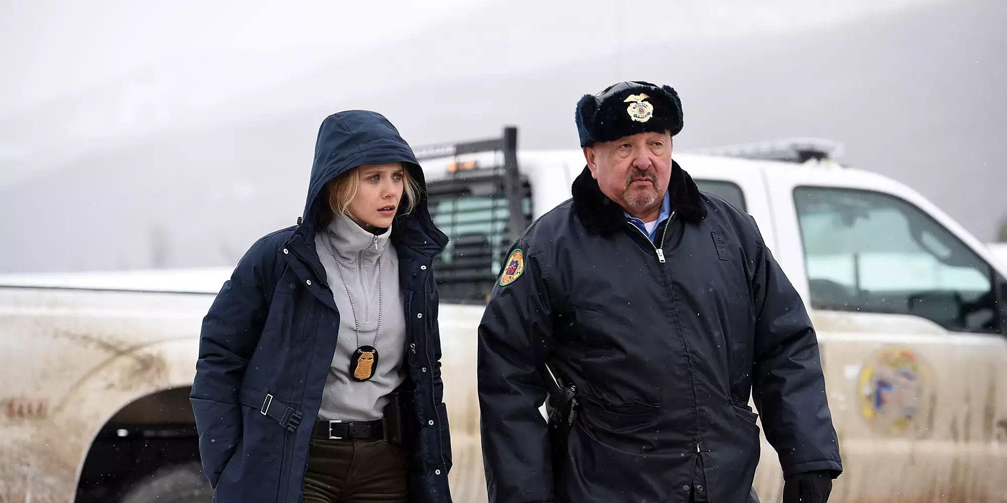 two law enforcement officers walking side by side in the snow