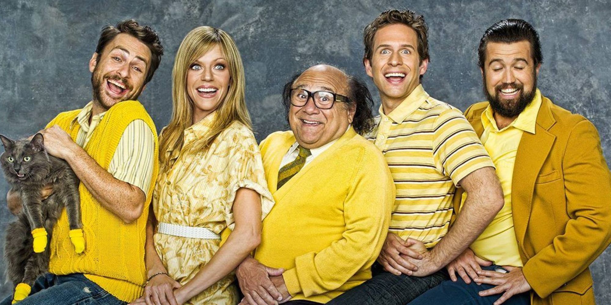 The cast of It's Always Sunny In Philadelphia smiling ridiculously for a photo.