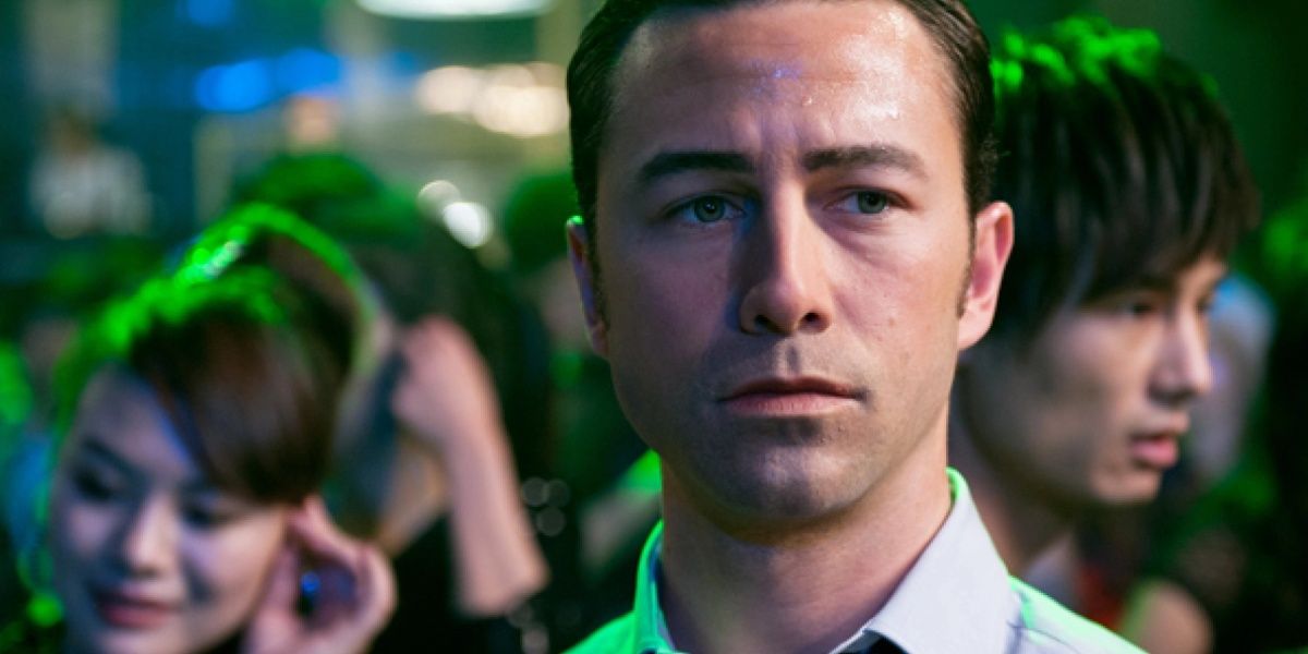 Joseph Gordon Levitt surrounded by neon lighting and other people