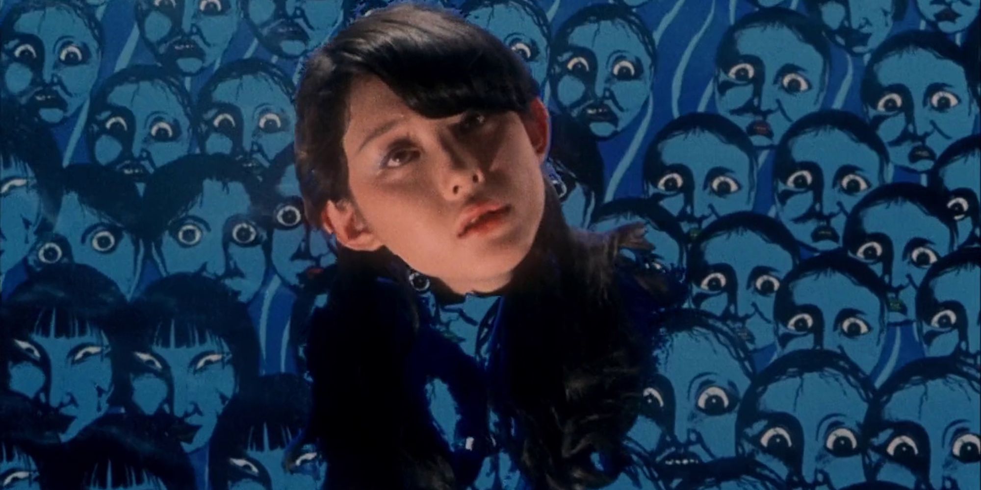 Disembodied head of young girl floating against a sea of blue-tinted faces