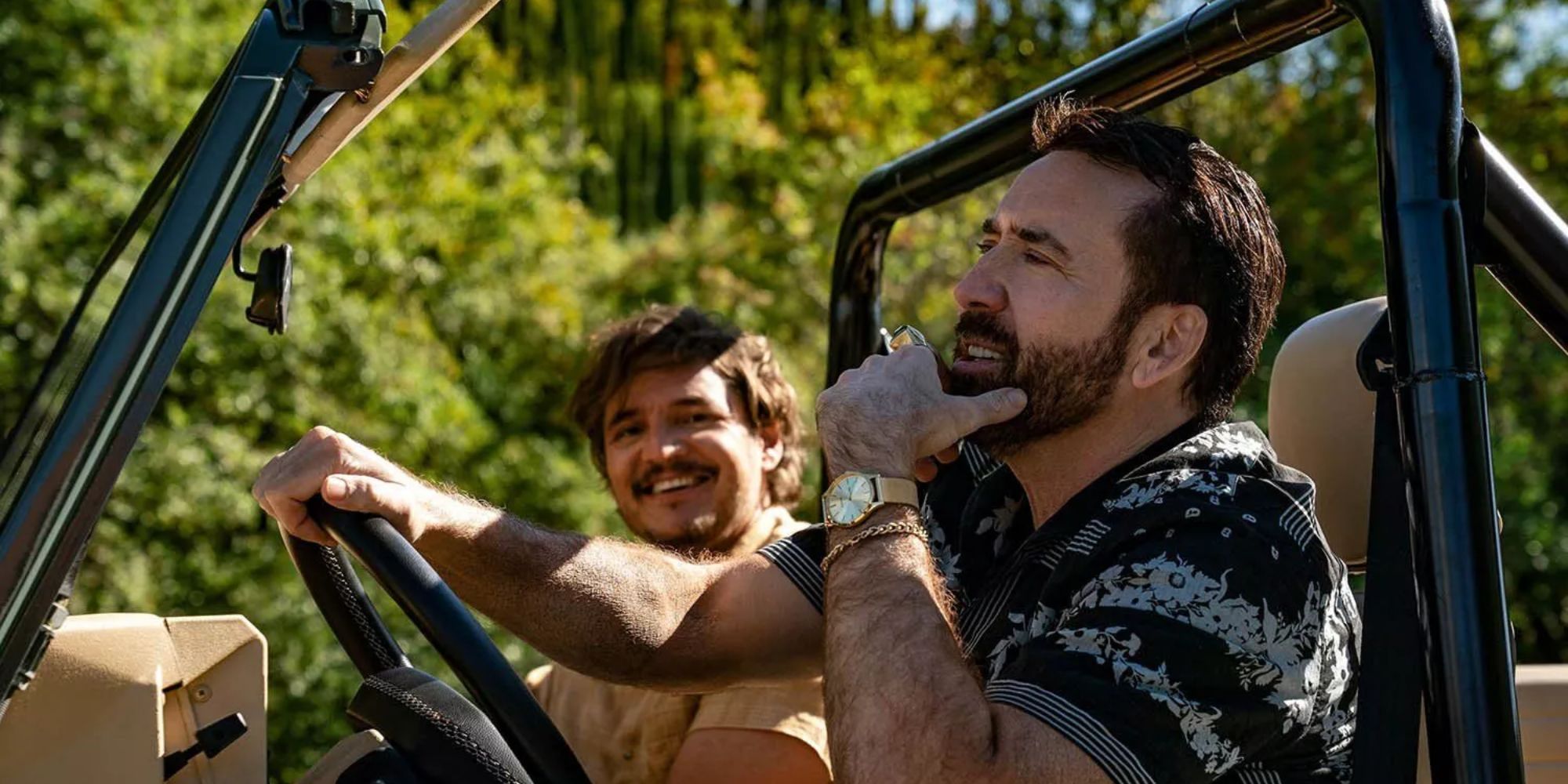 Nicolas Cage and Pedro Pascal sit in a Jeep in The Unbearable Weight of Massive Talent