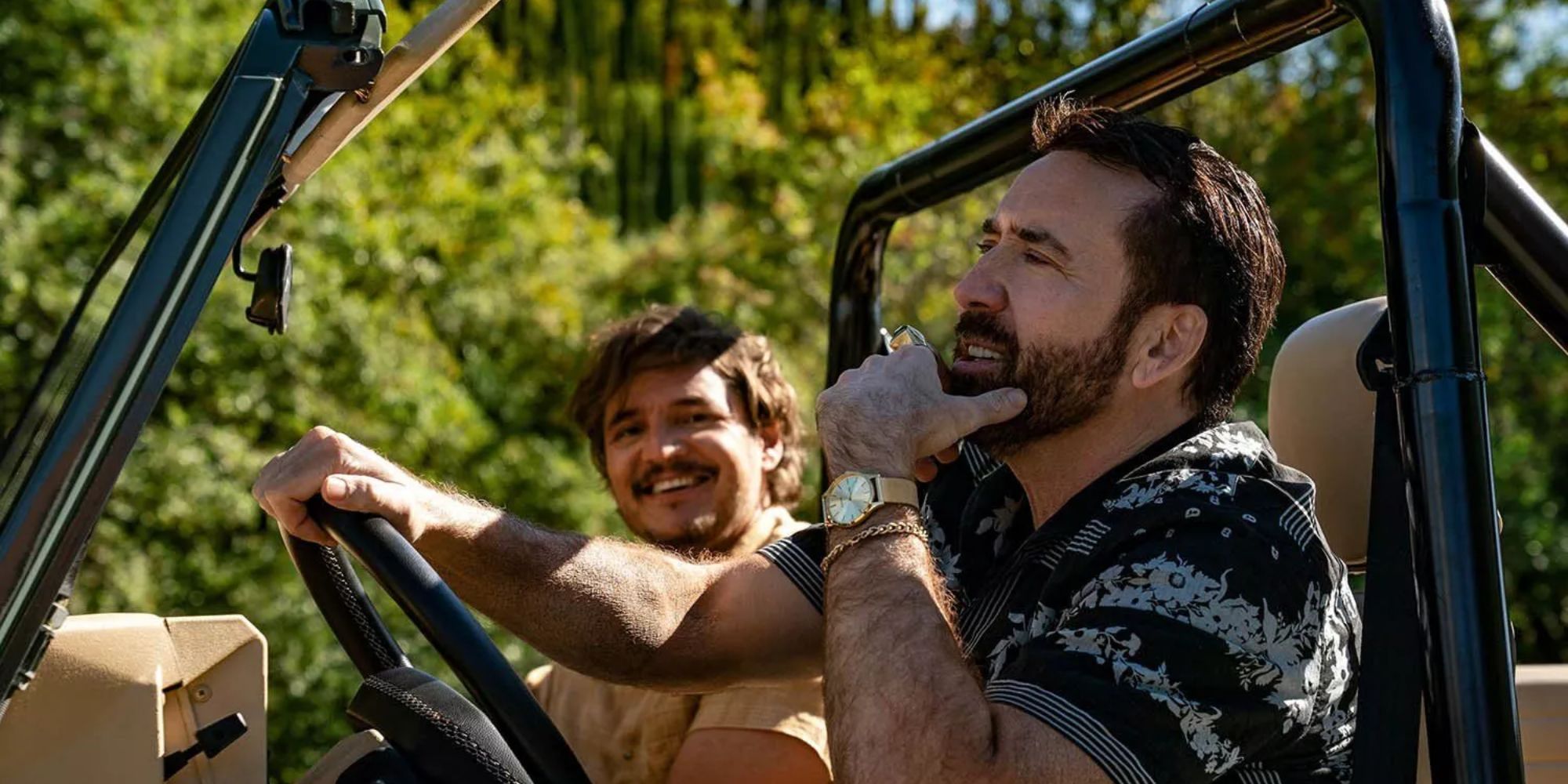 Nicolas Cage et Pedro Pascal assis dans une Jeep dans Le poids insupportable du talent massif