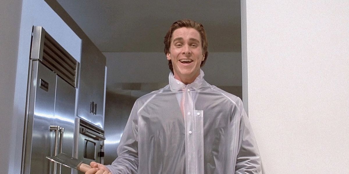 Christian Bale as Patrick Bateman wearing a clear plastic coat over his suit and carrying an axe in American Psycho