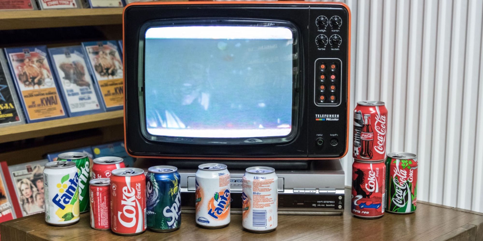 soda cans next to old school TV set