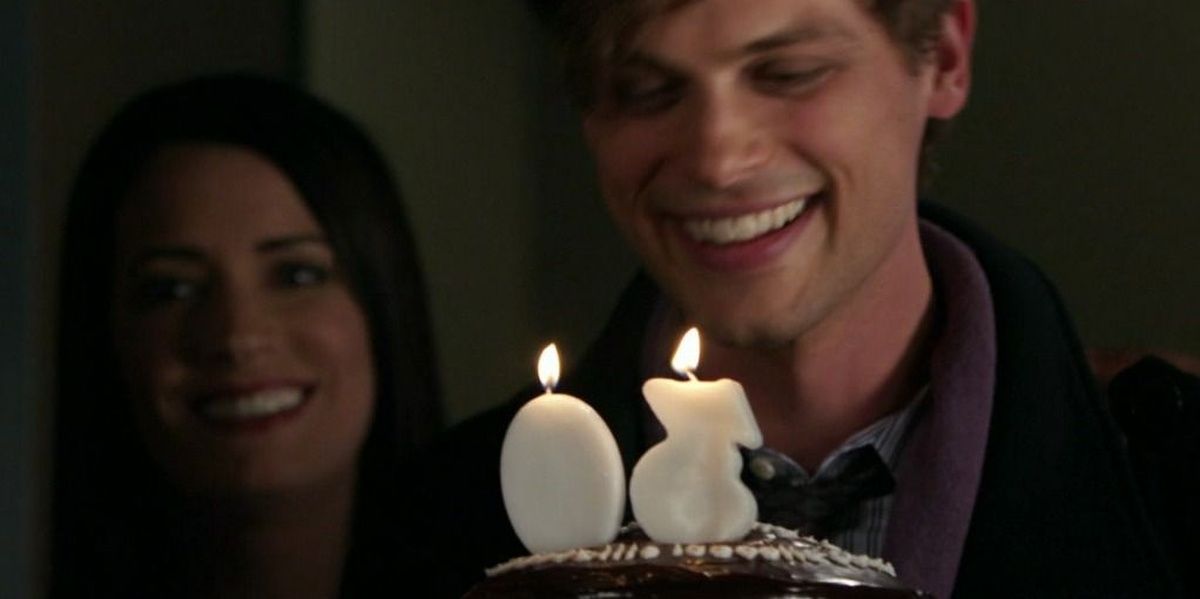 Spencer Reid holding a cake with the numbered candles &ldquo;30&rdquo;