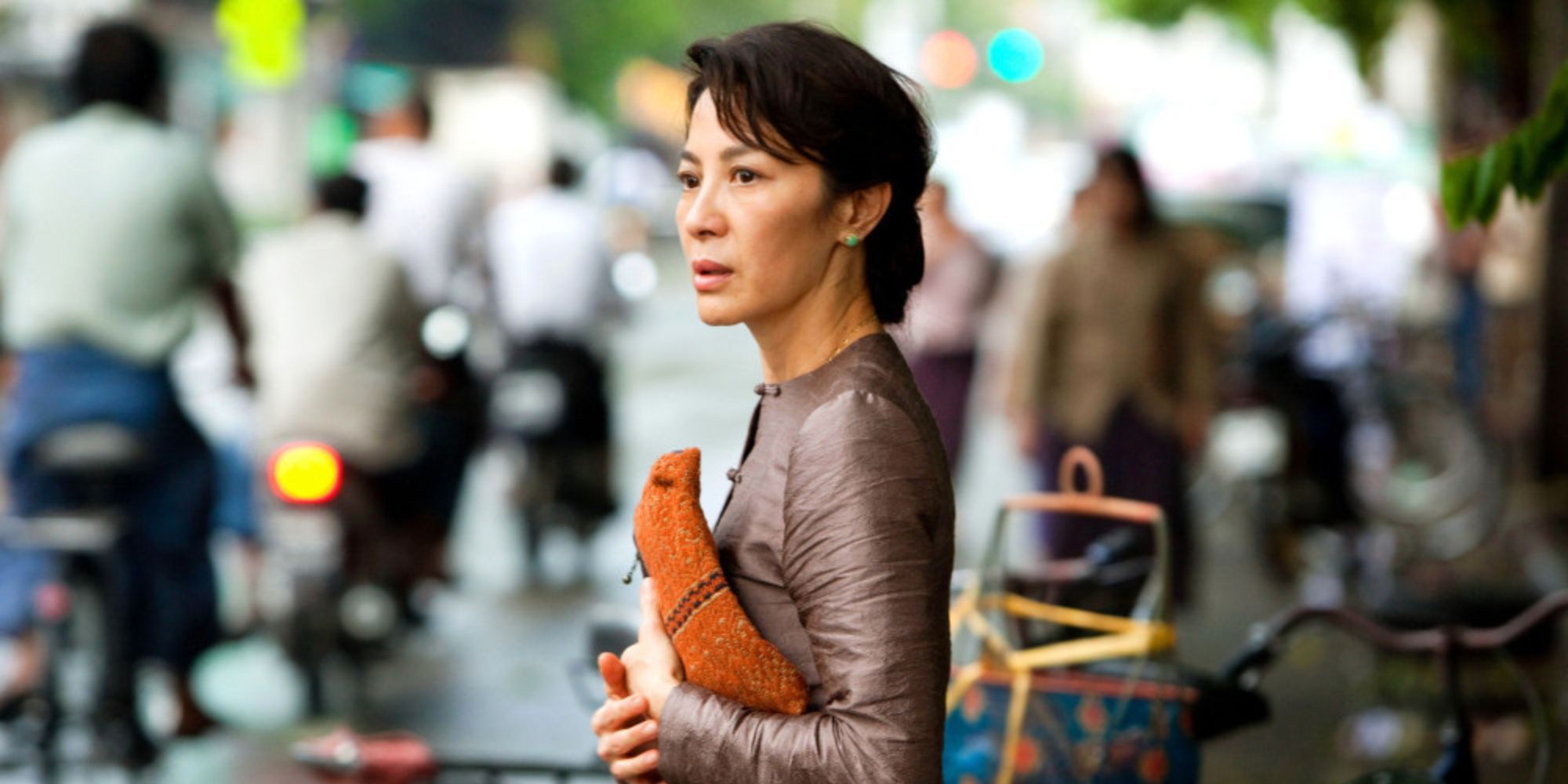 A woman is standing on the busy street