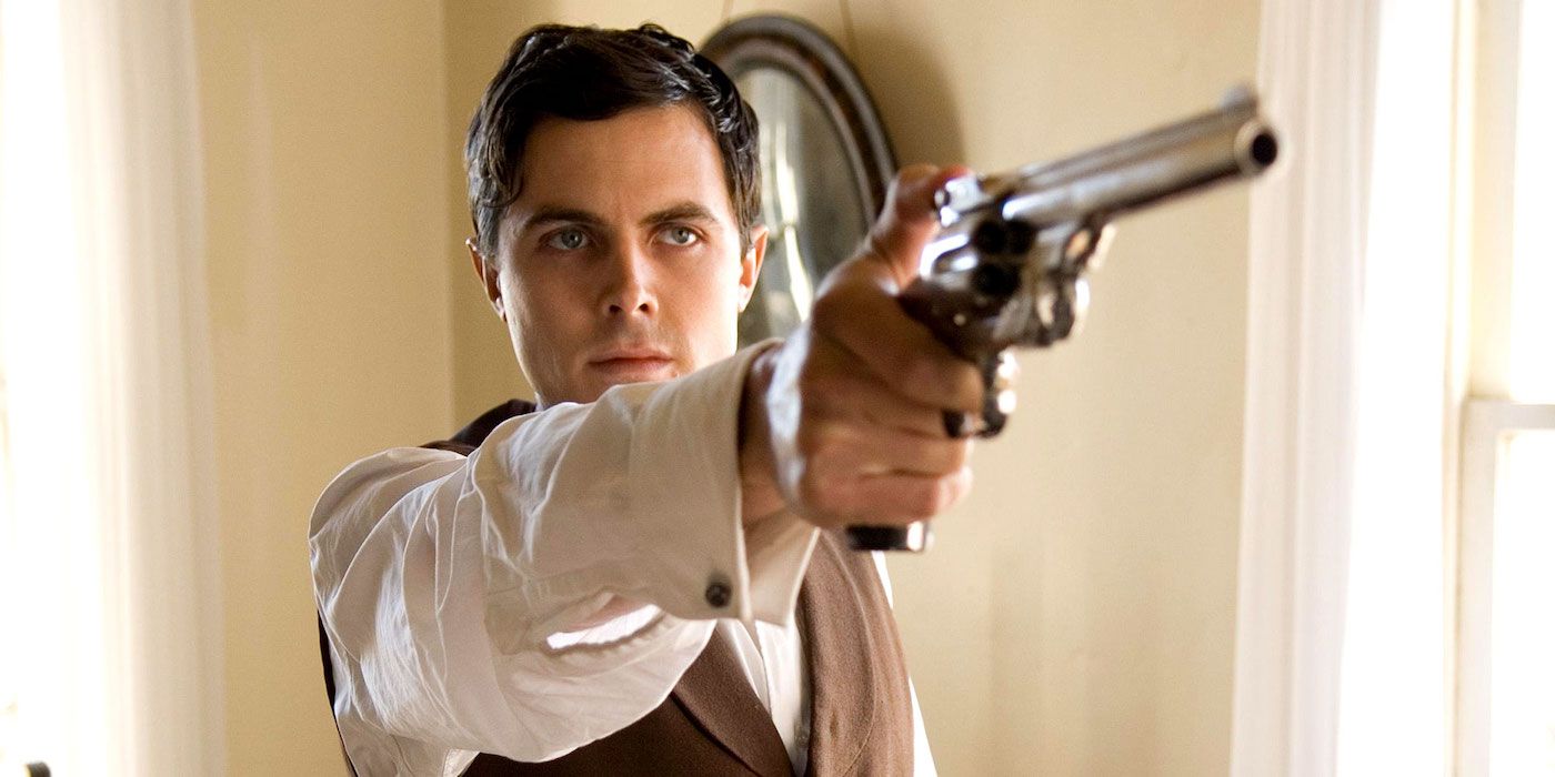 Robert Ford pointing a gun at someone off-camera in The Assassination of Jesse James by the Coward Robert Ford.
