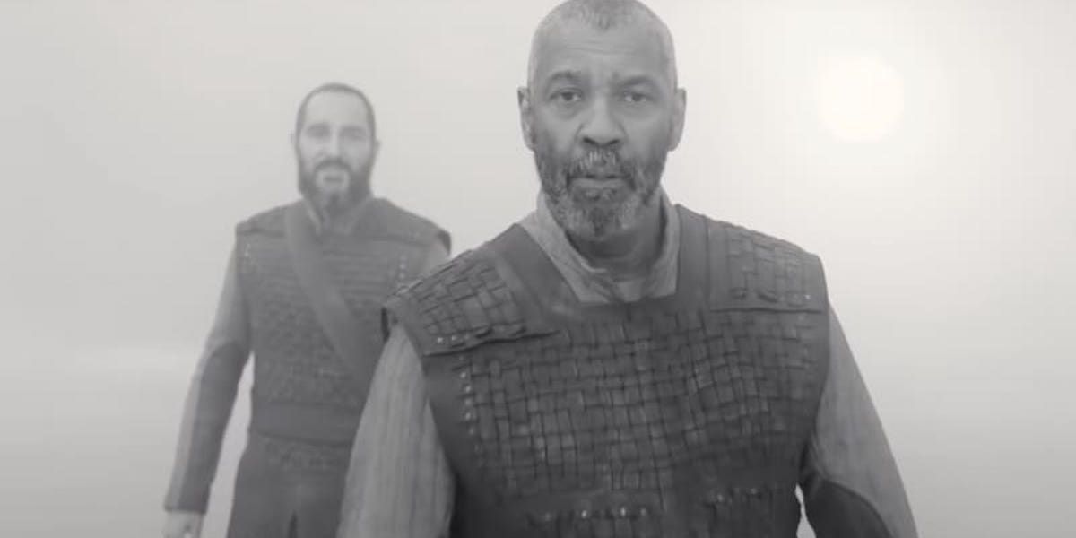 Black and white still of Denzel Washington in armor staring at the camera in The Tragedy of Macbeth