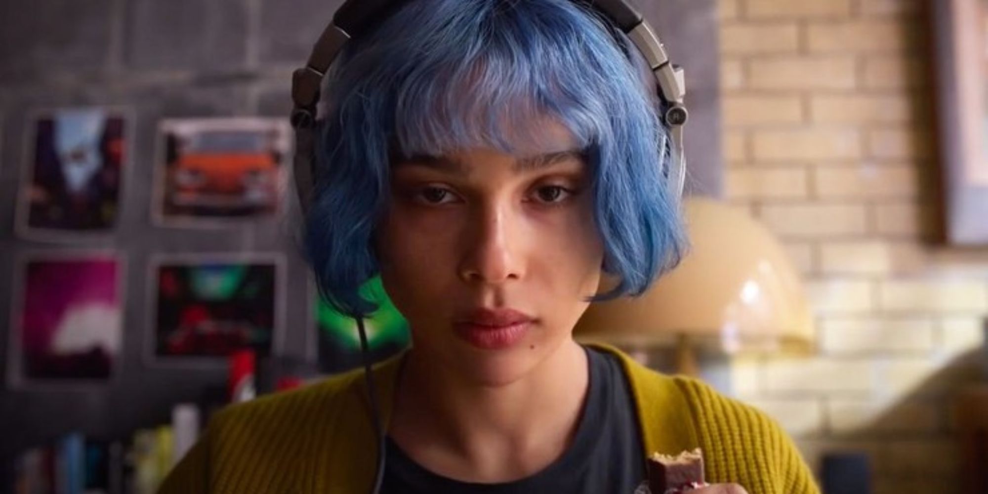 A blue haired mixed race woman is looking at the camera