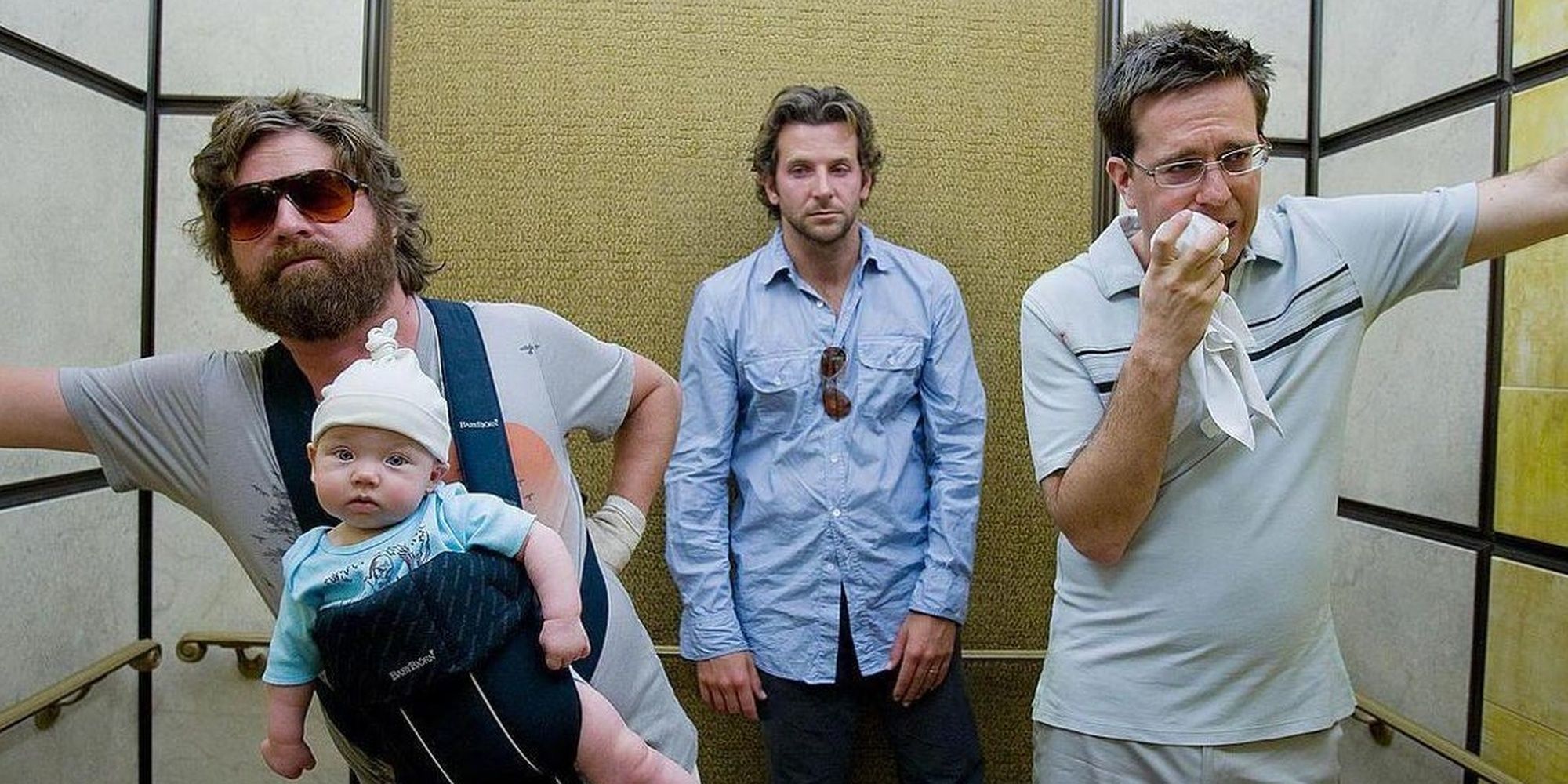 Three men looking disheveled while riding an elevator in 'The Hangover'.