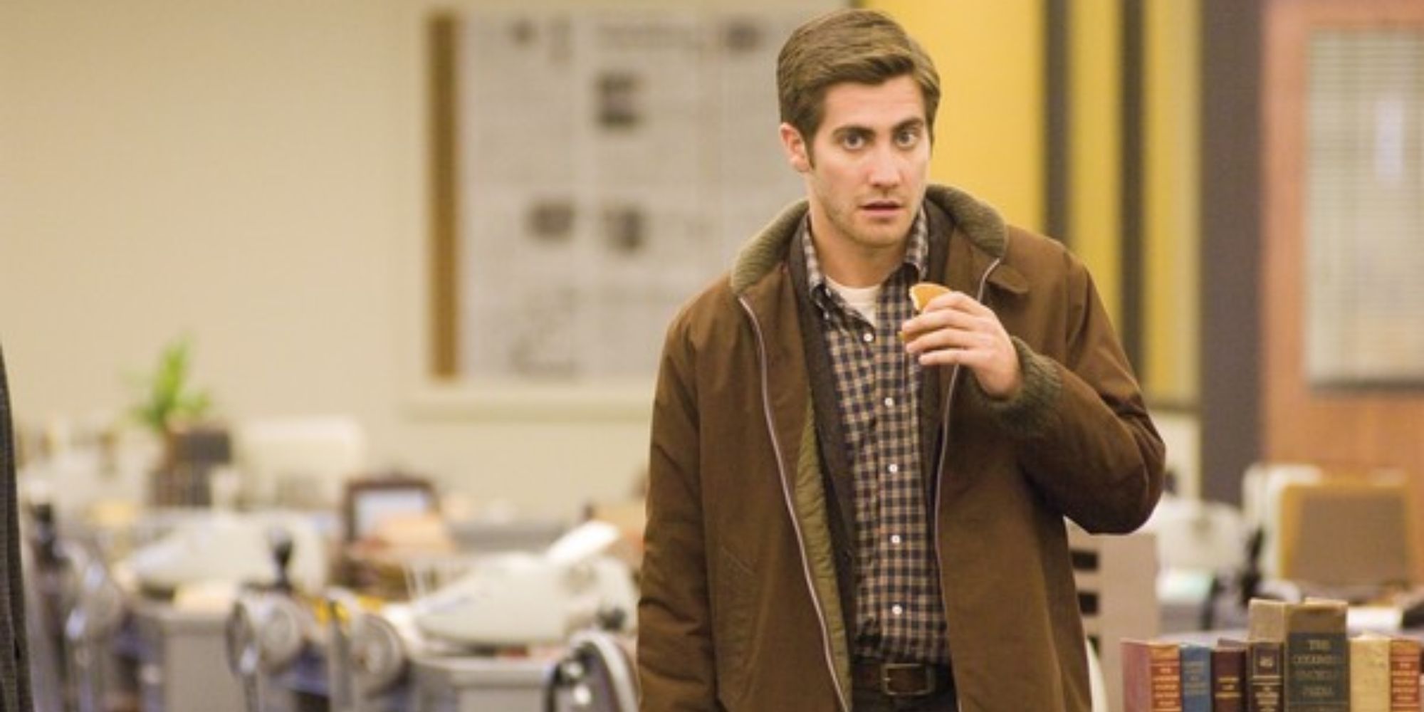 A man is standing with a piece of pancake in his hand