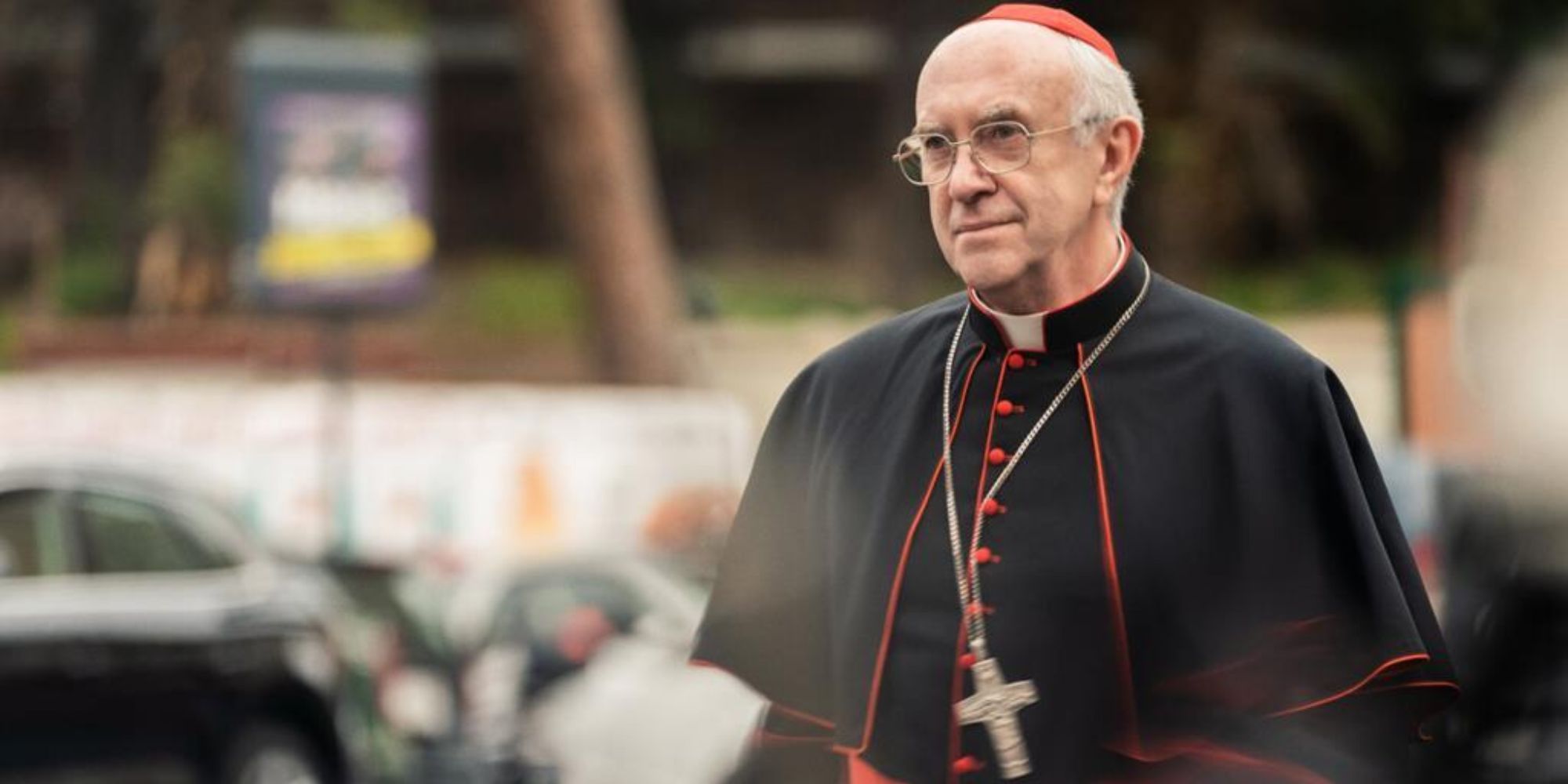 Pope Francis in his black outfit walks outside