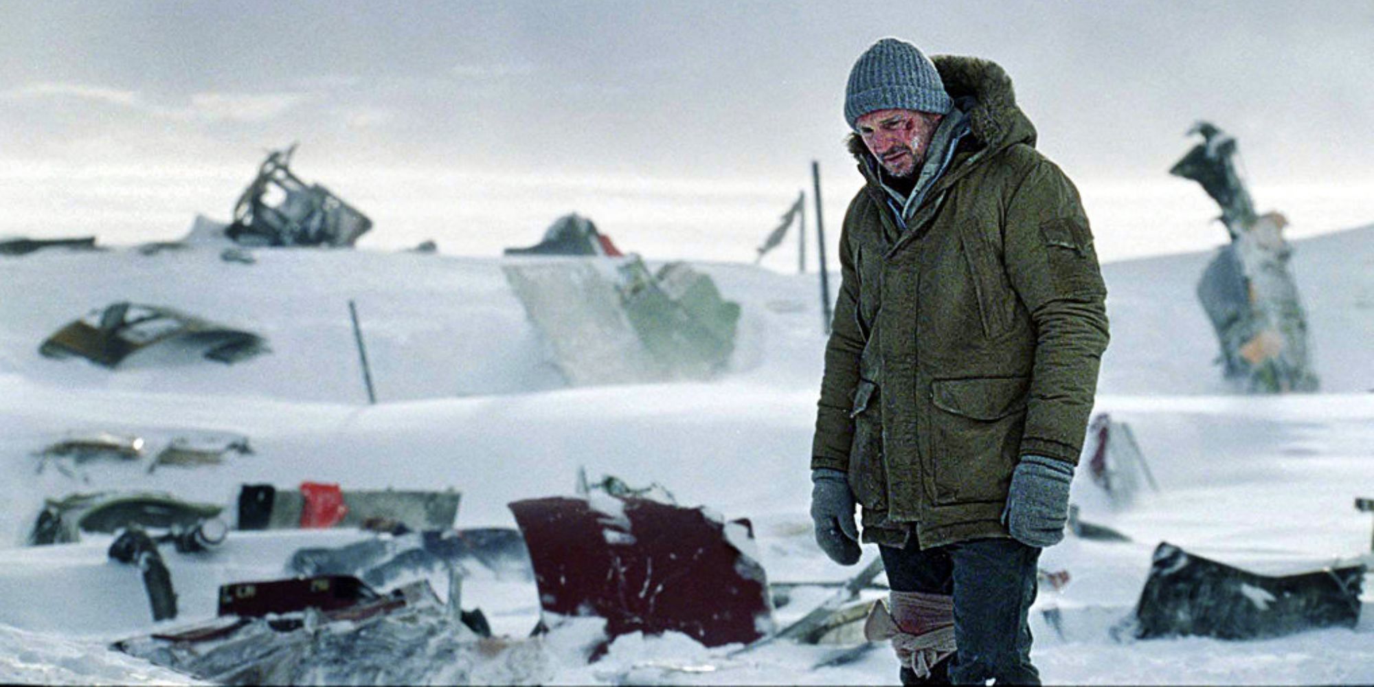 A man standing in the aftermath of a plane crash in the snow