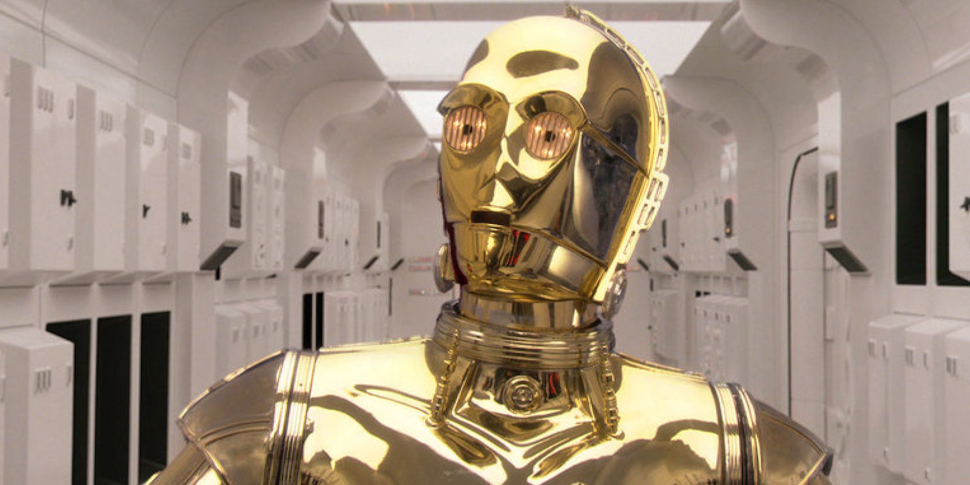 C3PO, played by Anthony Daniels, walks down a hallway on a ship in Star Wars: A New Hope