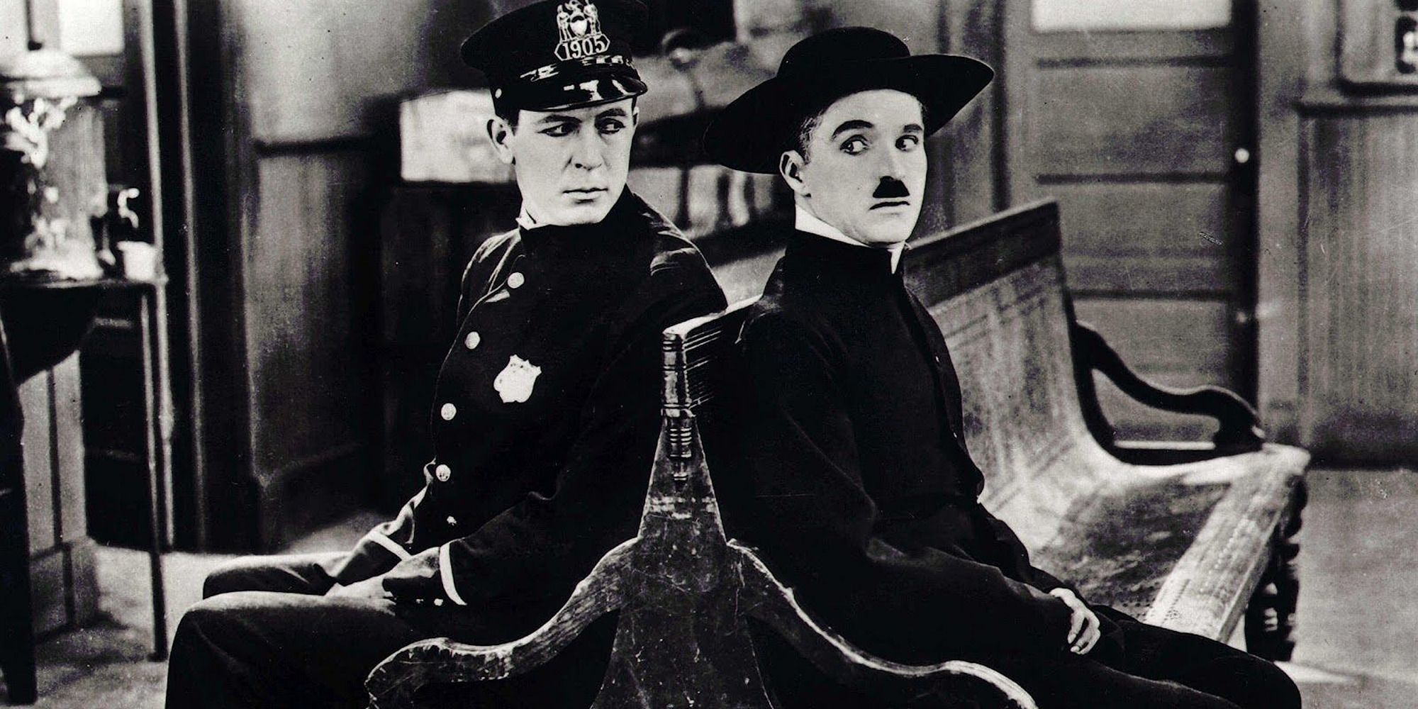 Charles Chaplin and a cop sitting in a bench in The Pilgrim