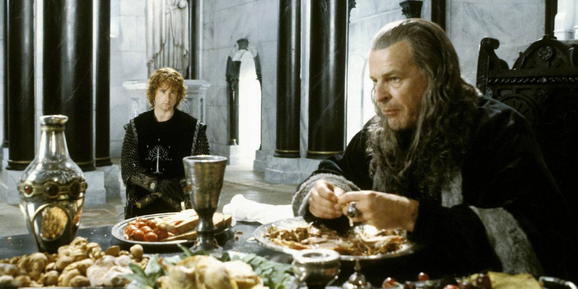 Denethor eating as Pippin looks on