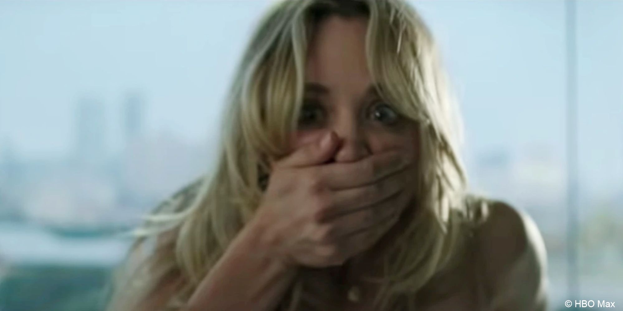 Cassie, naked from the shoulders up, slaps a hand over her mouth in horror