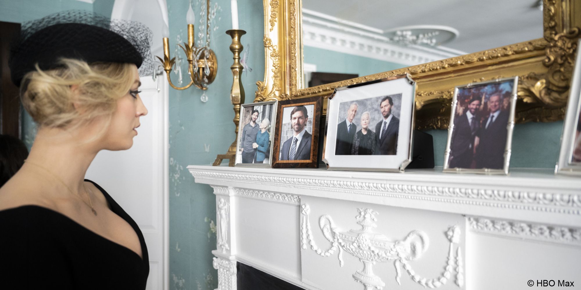 Cassie wears funeral blacks and looks at photos of the Sokolov family sitting on the mantle