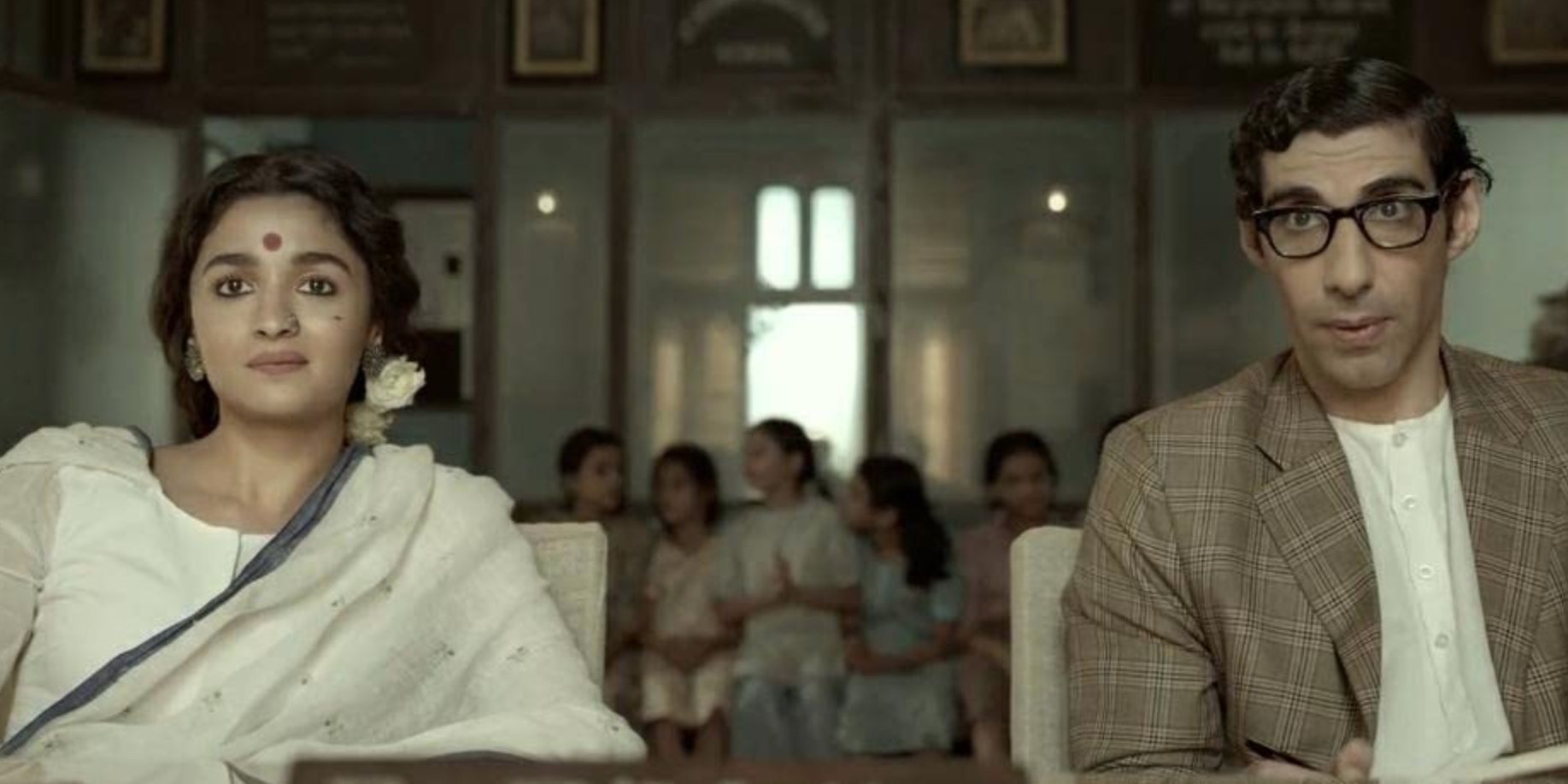 Alia Bhatt and a man sit at a table in 'Gangubai Kathiawadi'