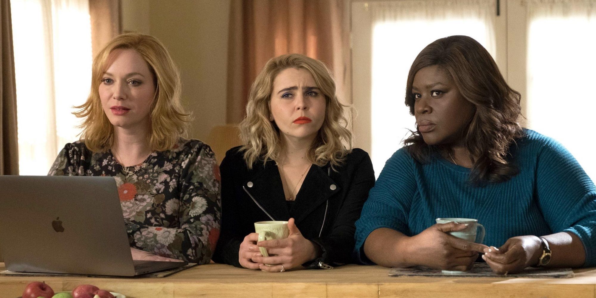 Three women sitting at a kitchen counter